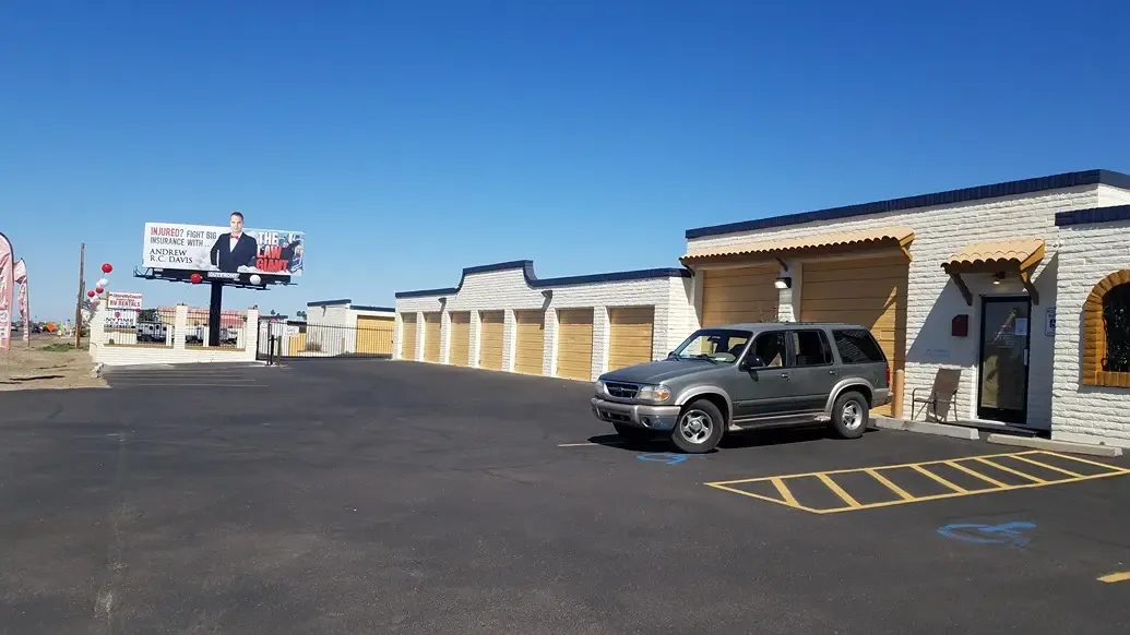 parking lot of the storage facility welcome center with a drive up units in the background
